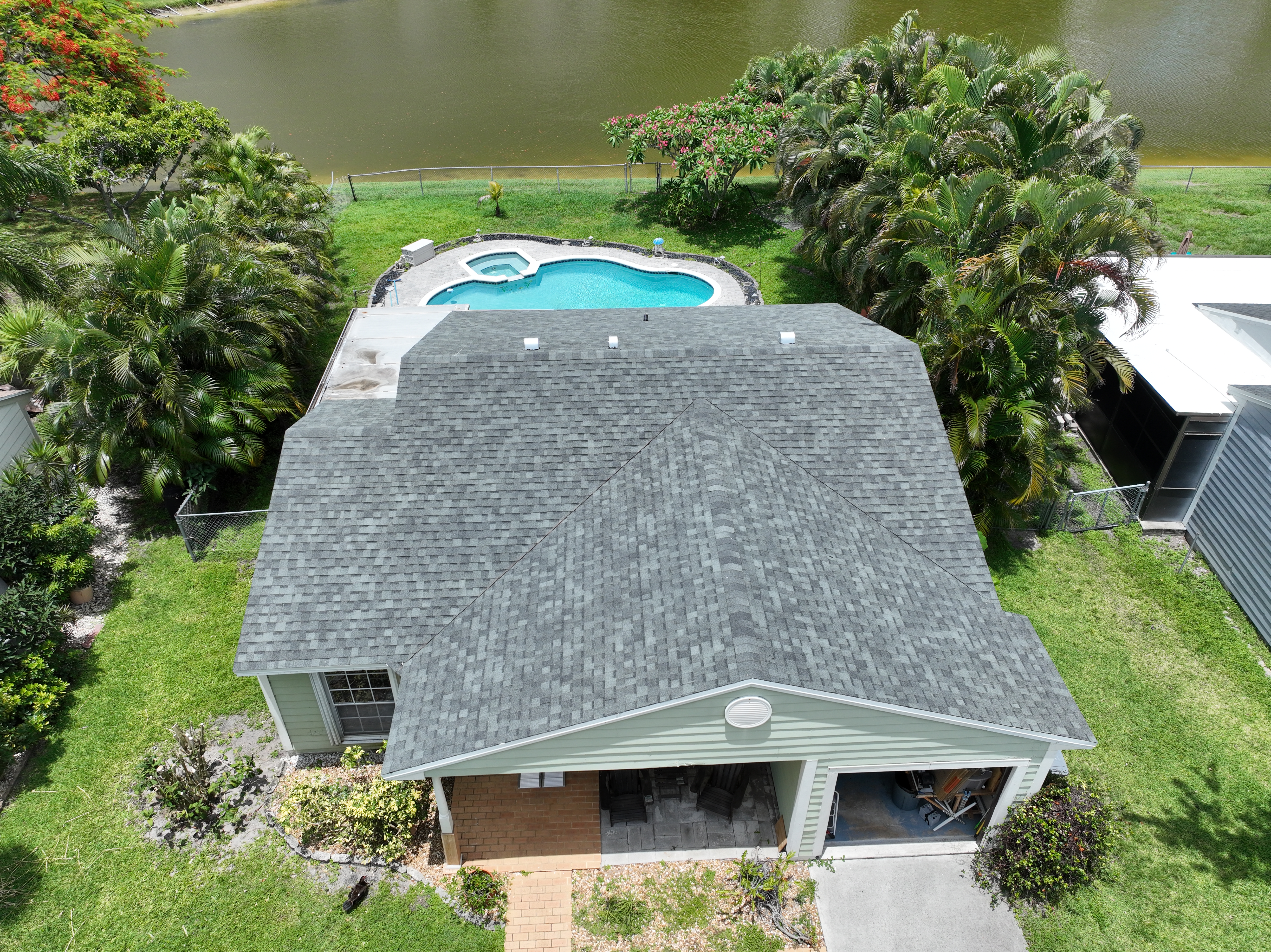 Gray shingle roof replacement with pool enclosure in Delray Beach, FL